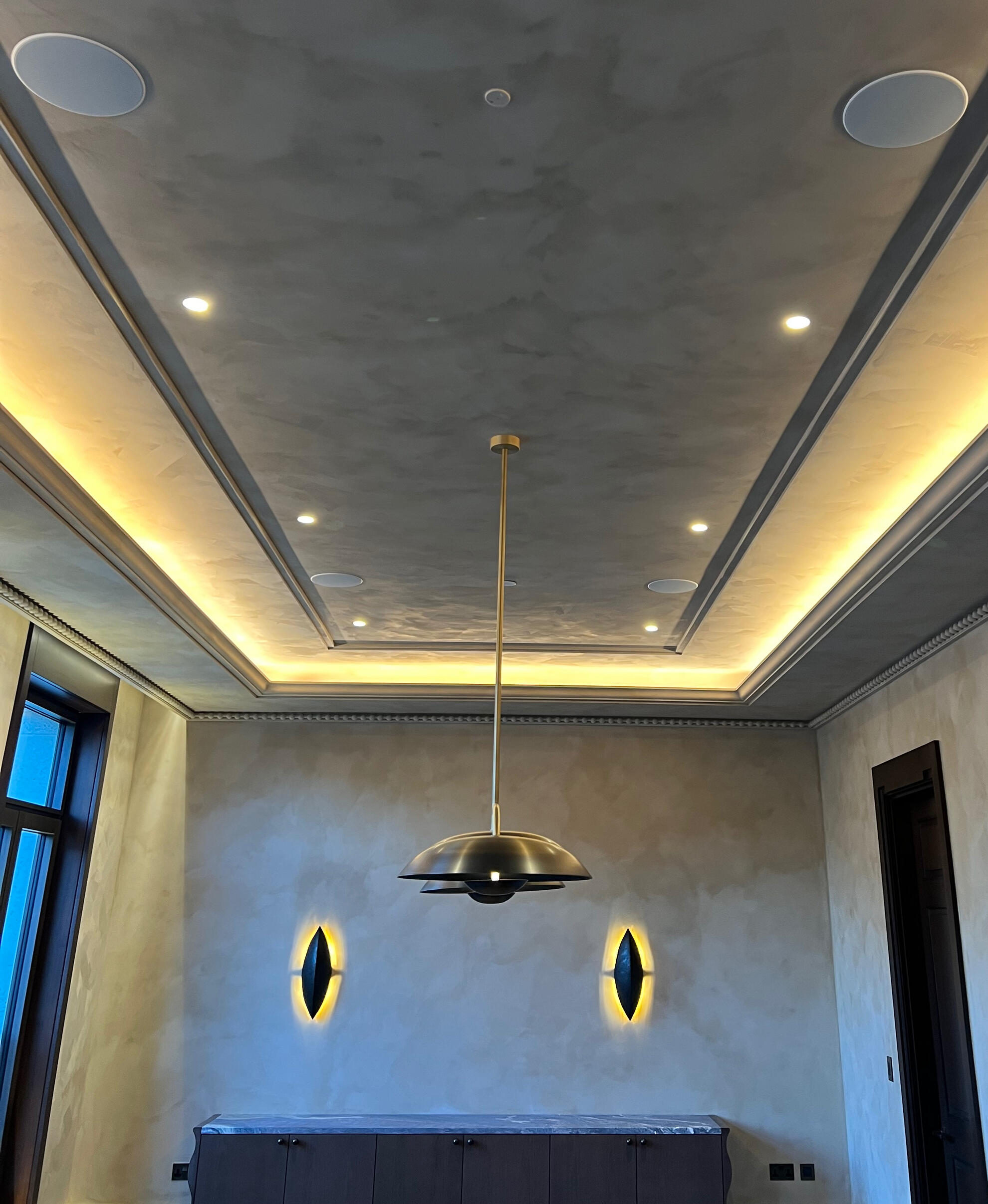 Limewashed coffered ceiling and cornice lit by concealed cove lighting